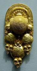 Etruscan Jewellery | Earring decorated with bosses, globule clusters, rosettes and filigree. Stamped gold sheet, 400–300 BC. | British Museum